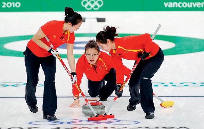 2010年2月17日，加拿大温哥华冬奥会冰壶比赛中，中国女队对阵英国女队。王冰玉（中）释放冰壶后，由另外两名队员用冰刷引导冰壶前行。在本届冬奥会上，中国女子冰壶队获得铜牌